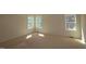 A bedroom featuring light-colored walls, base trim, carpeted floor and three double hung windows at 1105 Opal Ln # 70, Durham, NC 27705