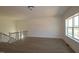 An open bonus room with a stairwell, hardwood floors and a large double hung window at 1105 Opal Ln # 70, Durham, NC 27705