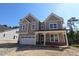 Charming two-story home featuring a welcoming front porch, attached garage, and neutral toned siding at 1105 Opal Ln # 70, Durham, NC 27705