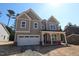Charming two-story home featuring a welcoming front porch, attached garage, and neutral toned siding at 1105 Opal Ln # 70, Durham, NC 27705