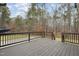 Dark stained wood deck with black railings and wooded backdrop at 1205 Smith Creek Way, Wake Forest, NC 27587