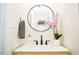 Modern bathroom with a round mirror and white sink at 128 Bruce Dr, Cary, NC 27511