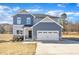 Two-story house with blue siding, stone accents, and a two-car garage at 148 Aylebury Rdg, Zebulon, NC 27597
