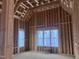 A bedroom under construction featuring wood framing, large windows, and ample natural light at 274 Westhampton Dr, Pittsboro, NC 27312