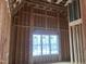 A bedroom under construction boasts exposed wood framing, angled ceilings, and large windows at 274 Westhampton Dr, Pittsboro, NC 27312