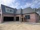 Brick garage exterior of a new home, featuring two garage doors and black-trimmed windows at 274 Westhampton Dr, Pittsboro, NC 27312