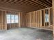 Unfinished room with wood framing, concrete floor, window and wood support beams at 274 Westhampton Dr, Pittsboro, NC 27312