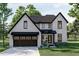 Two-story house with white siding, dark trim, and a brown garage door at 2961 Forest Creek Ln, Mebane, NC 27302