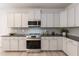 Modern kitchen with white cabinets, granite countertops, and stainless steel appliances at 33 Sunburst Ct, Fuquay Varina, NC 27526
