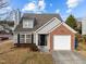 Gray siding house with brick accents, a two-car garage, and landscaping at 3838 Potecasi Dr, Raleigh, NC 27610