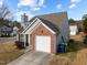 Side view of the house, showing the brick garage and landscaping at 3838 Potecasi Dr, Raleigh, NC 27610