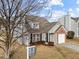 House exterior with gray siding, brick accents, and a two-car garage at 3838 Potecasi Dr, Raleigh, NC 27610