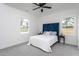 Inviting bedroom with a plush blue headboard, neutral walls, and ample natural light from two windows at 420 E Cedar Ave, Wake Forest, NC 27587