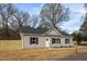 Exterior shot of a gray home with a dark roof, a new fence, and tidy landscaping, offering great curb appeal at 420 E Cedar Ave, Wake Forest, NC 27587