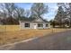 The front of the home features a gray siding exterior, a new wooden fence, and well-maintained landscaping at 420 E Cedar Ave, Wake Forest, NC 27587