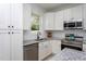 Well-lit kitchen featuring sleek countertops, stainless steel appliances, white cabinets, and modern fixtures at 420 E Cedar Ave, Wake Forest, NC 27587