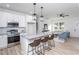 Bright, open kitchen and living area with white cabinets, modern appliances, and sleek bar stool seating at 420 E Cedar Ave, Wake Forest, NC 27587