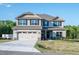 Two-story house with beige siding, gray stone accents, and a three-car garage at 45 River Chapel Dr, Fuquay Varina, NC 27526