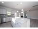 Modern kitchen with white cabinets, granite countertops, and a large island at 45 River Chapel Dr, Fuquay Varina, NC 27526