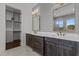 Bathroom featuring dual vanities with dark wood cabinets, shiplap wall, and gold fixtures at 4912 Hidden Pasture Way, Zebulon, NC 27597