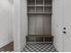 Mudroom with built-in storage, hooks, a bench and a patterned floor at 4912 Hidden Pasture Way, Zebulon, NC 27597