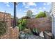 Landscaped courtyard with brick walls, potted plants, and a stone path at 7010 Sandy Forks Rd # 102, Raleigh, NC 27615