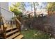 Small, fenced backyard with brick wall and potted plants at 7010 Sandy Forks Rd # 102, Raleigh, NC 27615