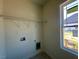 Practical laundry area with shelving and connections, illuminated by natural light from a nearby window at 899 Olive Branch Dr, Smithfield, NC 27577