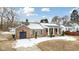 Brick ranch house with a covered porch and snowy yard at 927 Bellvue St, Burlington, NC 27217