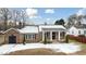 Brick ranch house with a covered porch and snowy yard at 927 Bellvue St, Burlington, NC 27217