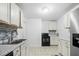 Updated kitchen with white cabinets, stainless steel appliances, and tile floors at 927 Bellvue St, Burlington, NC 27217
