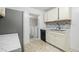 Kitchen with white cabinets, stainless steel appliances, and view into laundry room at 927 Bellvue St, Burlington, NC 27217
