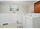 Laundry room with washer, dryer, and brick accent wall at 927 Bellvue St, Burlington, NC 27217