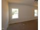 Bright bedroom featuring neutral walls, carpeted floors, and windows providing ample natural light at 1104 Opal Ln # 104, Durham, NC 27705