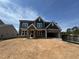 New construction home featuring stone accents, an attached garage, and a classic two-story design under a blue sky at 1104 Opal Ln # 104, Durham, NC 27705
