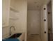 Functional laundry area with sink, countertop, shelving, and white door at 1104 Opal Ln # 104, Durham, NC 27705