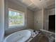 Bathroom with a soaking tub and large window; ready for your custom finishes at 1109 Opal Ln # 71, Durham, NC 27705