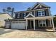 Charming two-story home featuring a three-car garage, gray siding, black shutters, and brick accents at 1109 Opal Ln # 71, Durham, NC 27705