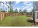 Spacious backyard with a wooden fence, trampoline, and young trees at 1141 Logperch Way, Wendell, NC 27591