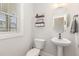 Stylish bathroom with pedestal sink, white toilet and a decorative mirror at 1141 Logperch Way, Wendell, NC 27591