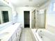 Primary bathroom with dual sinks, soaking tub and glass enclosed shower provides a spa-like experience at 121 Gratiot Dr, Morrisville, NC 27560