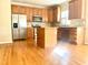 Spacious kitchen features stainless steel refrigerator, microwave, wooden cabinets and a center island with seating at 121 Gratiot Dr, Morrisville, NC 27560