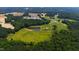 Scenic aerial view of a large property with a pond surrounded by lush greenery and mature trees at 14425 Nc-96 N Hwy, Zebulon, NC 27597