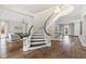 Elegant curved staircase with white railings and dark wood treads at 14425 Nc-96 N Hwy, Zebulon, NC 27597