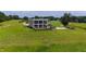 Exterior view showcasing the custom luxury home with elevated patio and balcony overlooking sprawling manicured lawn at 14425 Nc-96 N Hwy, Zebulon, NC 27597