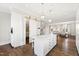 White kitchen with large island, pantry access, and hardwood floors at 14425 Nc-96 N Hwy, Zebulon, NC 27597