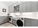 Modern laundry room with gray cabinets, a farmhouse sink, and new appliances at 14425 Nc-96 N Hwy, Zebulon, NC 27597
