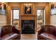 Sophisticated living room with fireplace, leather armchairs, and views of outdoor landscape at 14425 Nc-96 N Hwy, Zebulon, NC 27597