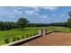 Outdoor patio featuring a small table with chairs and views of the lush green lawns and trees at 14425 Nc-96 N Hwy, Zebulon, NC 27597