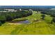 Aerial view of pond with trees, lush green space, and a view of the luxury home in the background at 14425 Nc-96 N Hwy, Zebulon, NC 27597